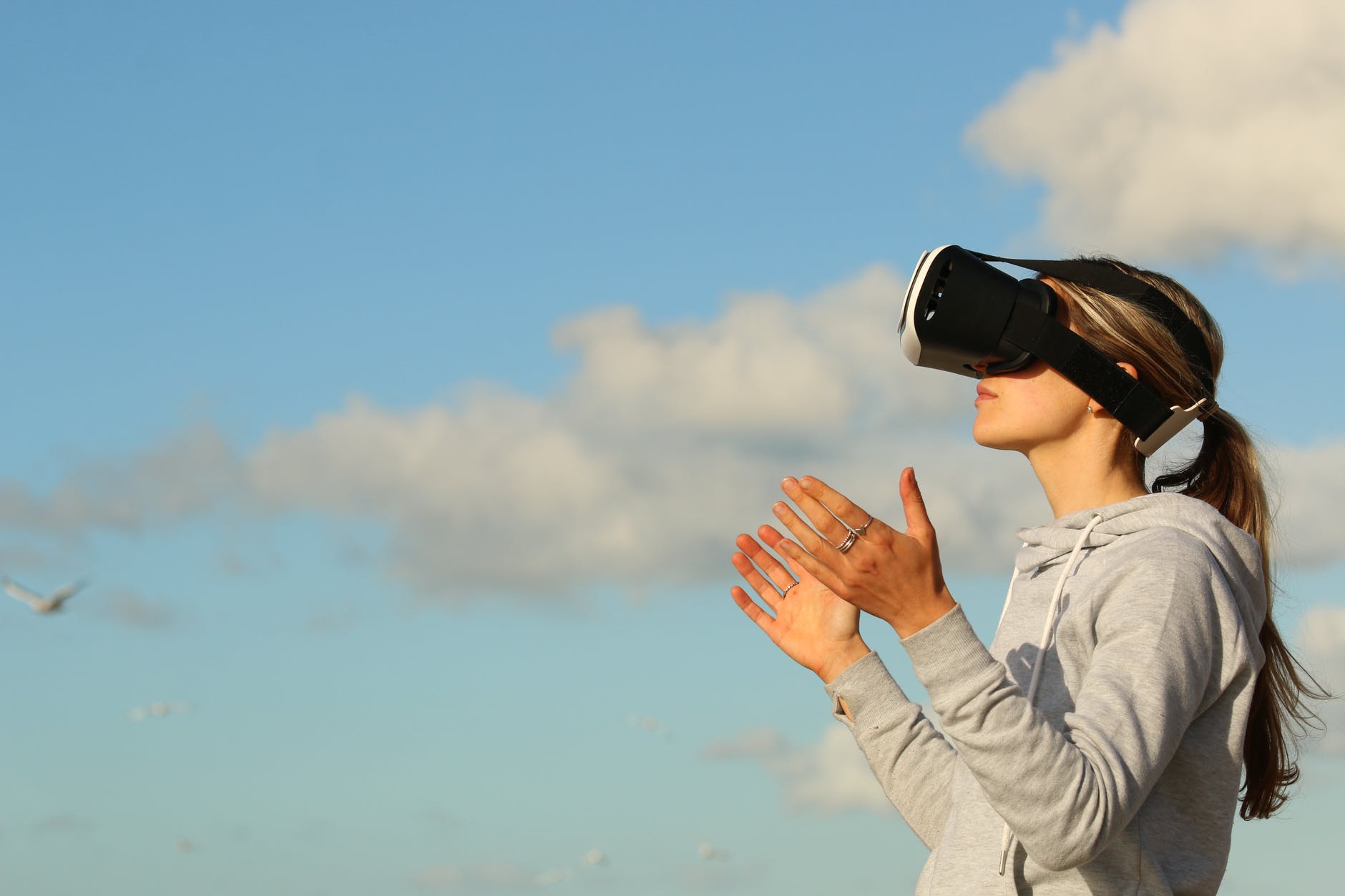 Imagen en la que aparece una mujer al aire libre utilizando unas gafas de realidad virtual